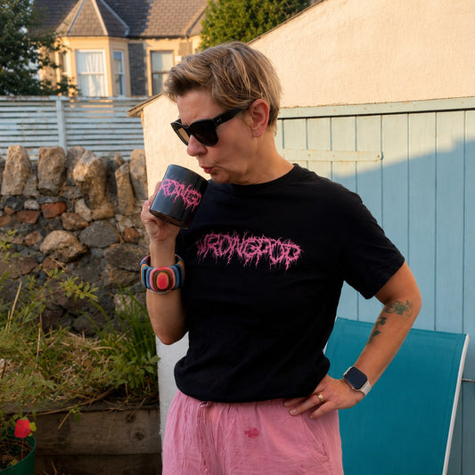 Wrongpop pink logo mug — lifestyle shot, person drinking from mug